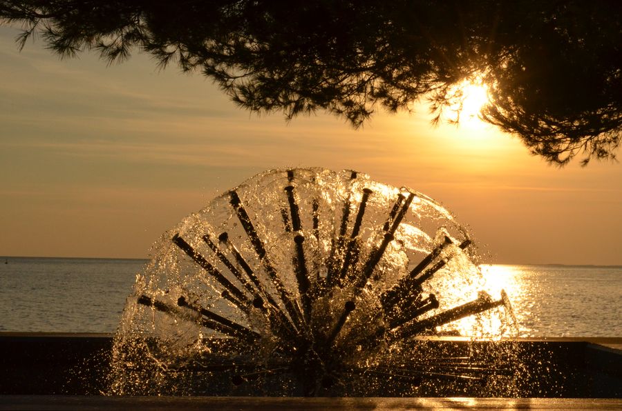 The setting sun seen through a fountain